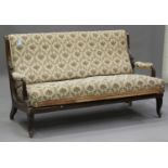 A late 19th Century Continental walnut showframe settee with carved downswept arms, upholstered in a