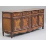 A 20th century French walnut enfilade sideboard with carved and inlaid decoration, fitted with