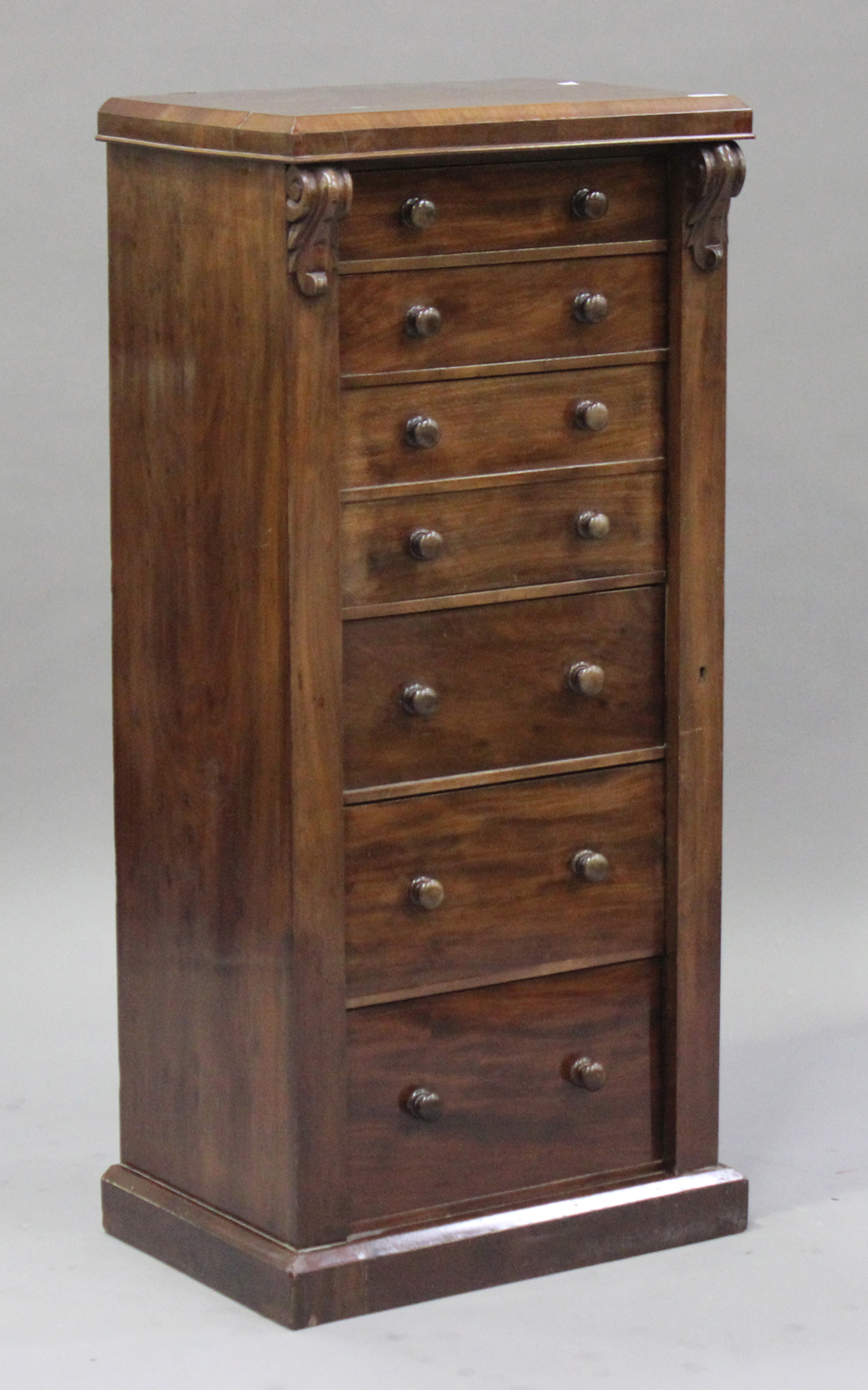 A late Victorian mahogany secrétaire Wellington chest, fitted with six drawers flanked by carved