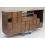 A 20th century South-east Asian elm side cabinet, fitted with an arrangement of drawers and open
