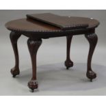 A George V mahogany oval dining table with single extra leaf, the gadrooned top raised on carved