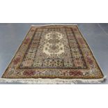 An Indian carpet, mid-20th century, the ivory field with a floral medallion and sprays, within a