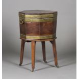 A George III mahogany and brass bound cellaret of octagonal form, the hinged lid enclosing a lead-