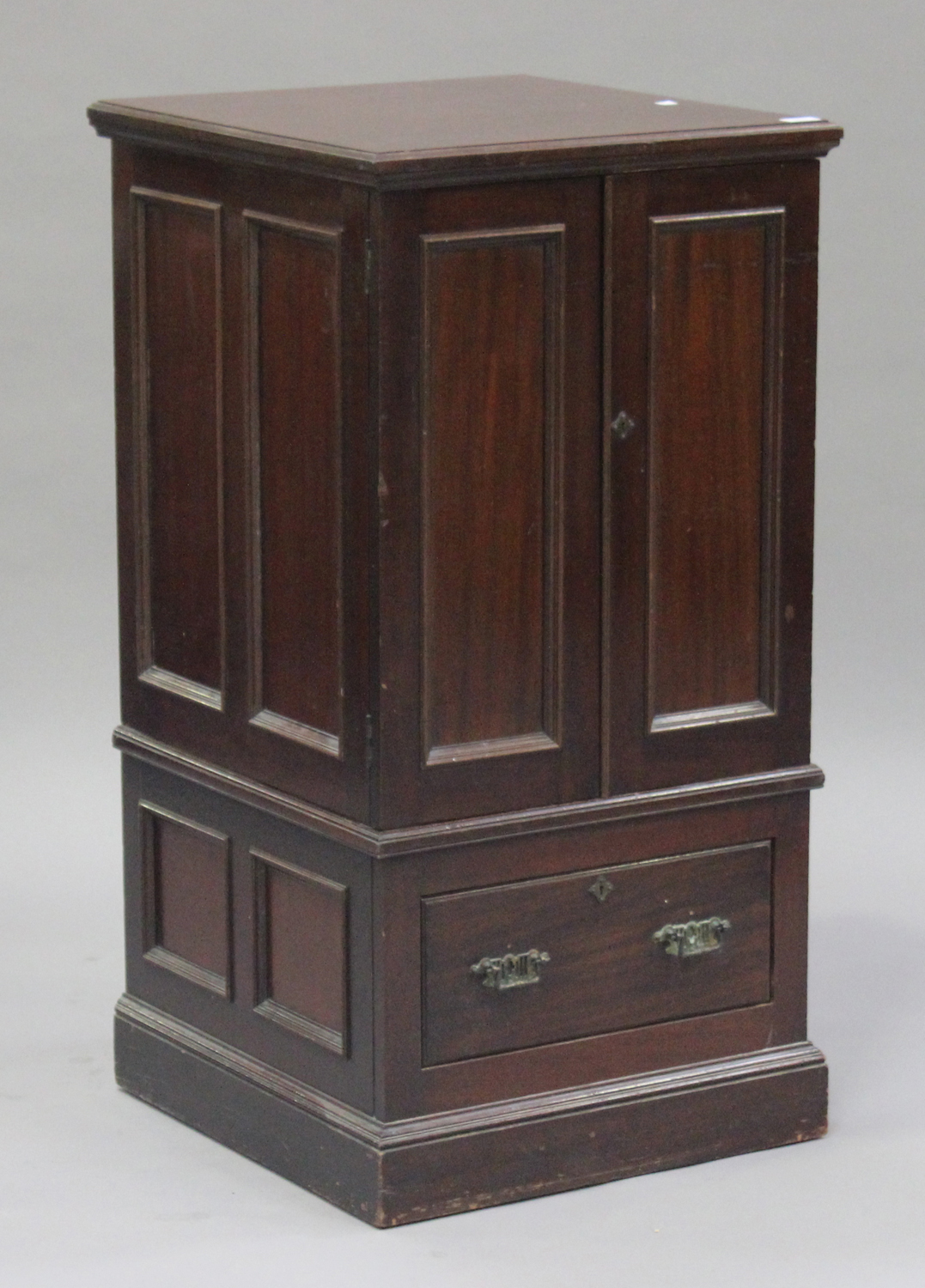 An Edwardian mahogany side cabinet, fitted with a pair of panel doors above a drawer, on a plinth