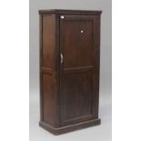 A mid-20th century stained pine side cupboard, fitted with a panel door, on a plinth base, height