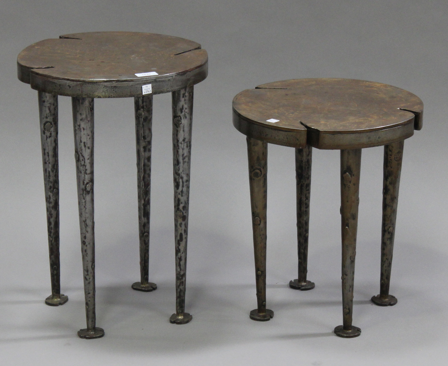 A pair of modern graduated wrought metal circular occasional tables, on tapering legs, diameter