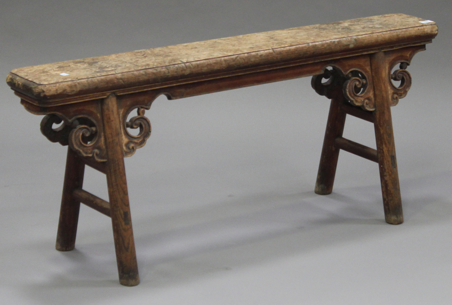 A 19th century Chinese elm and softwood bench with carved supports, on turned legs, height 51cm,