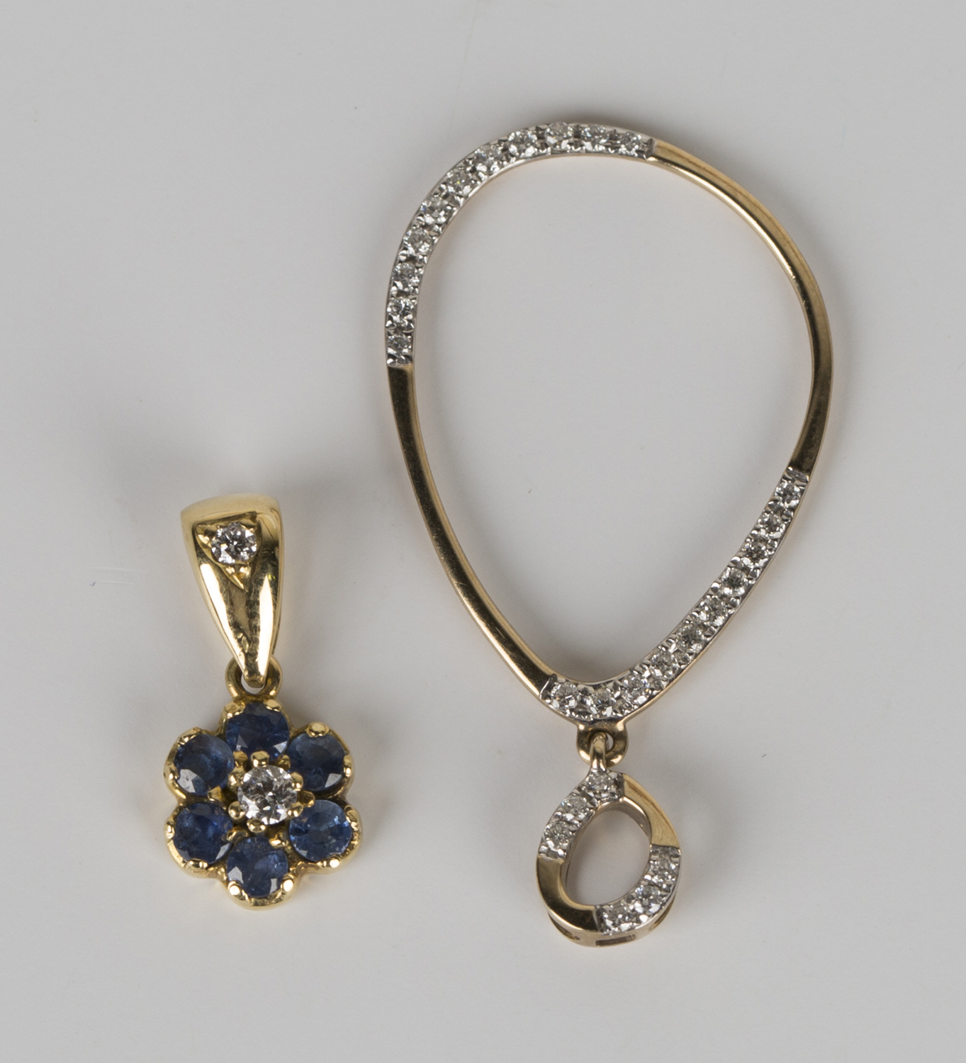 A gold and diamond pendant of oval hoop form with diamond set sections and a similar suspension