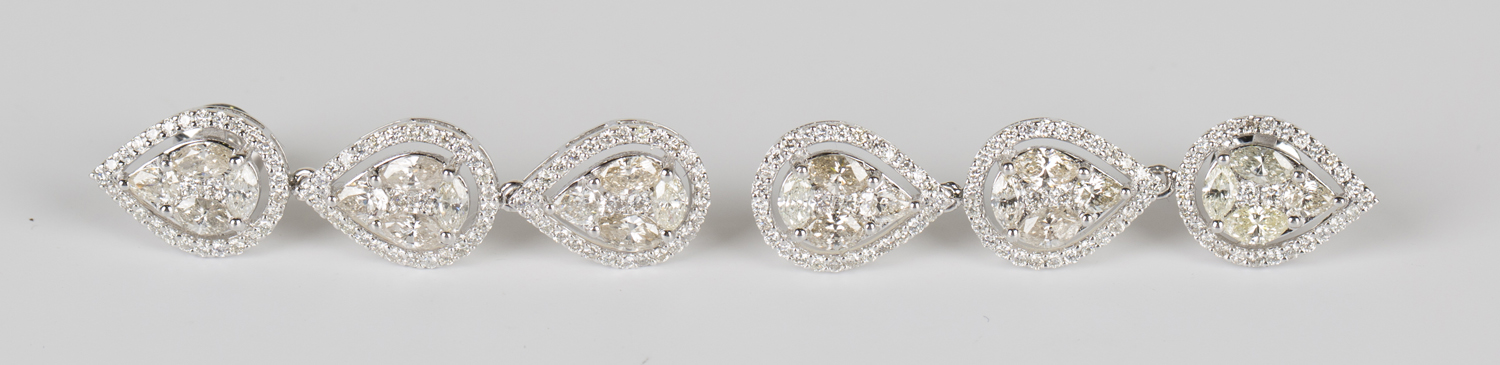 A pair of white gold and diamond triple cluster pendant earrings, each pear shaped cluster set