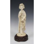 A Japanese carved ivory okimono figure of a bijin, Meiji period, the standing maiden modelled