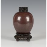 A Chinese iron rust glazed porcelain ovoid jar, Qing dynasty, covered in a lustrous reddish-brown