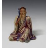 A Chinese flambé glazed pottery figure of a seated sage, early 20th century, modelled seated, his