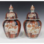 A pair of Japanese Imari porcelain jars and covers, Meiji period, each lobed ovoid body and domed