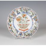 A Chinese famille verte export porcelain fluted circular dish, Kangxi period, the central panel