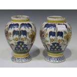 A pair of Dutch Delft polychrome painted vases, late 18th century, the high shouldered tapered