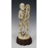 A Japanese carved ivory okimono figure of a monkey trainer, Meiji period, modelled standing with the