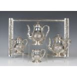 A Chinese silver four-piece tea set and tray, early 20th century, comprising teapot and cover, hot