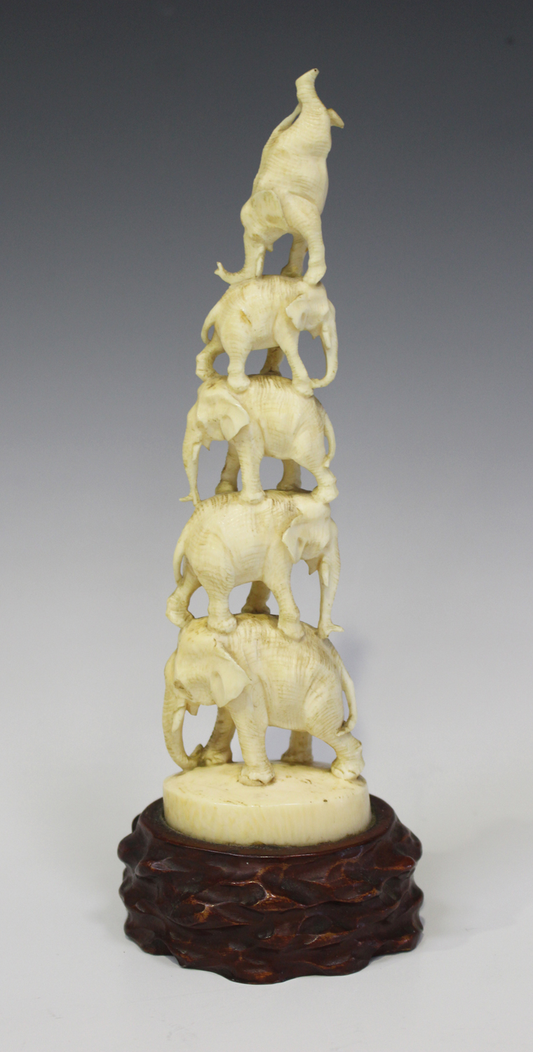 A Japanese ivory okimono figure group, Meiji period, carved and pierced with five balancing