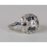 A platinum, sapphire and diamond ring, collet set with the principal circular cut diamond within a