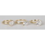 Three 14ct gold and colourless gem set solitaire rings with slight variations in design.Buyer’s