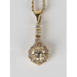 A gold and diamond pendant, designed as a circular cluster with the principal circular cut diamond