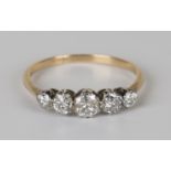 A gold and diamond set five stone ring, claw set with a row of circular cut diamonds graduating in