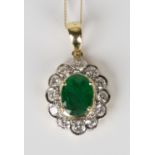 An 18ct gold, emerald and diamond pendant, claw set with an oval cut emerald within a surround of
