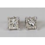 A pair of white gold and diamond single stone earstuds, each claw set with a princess cut diamond,