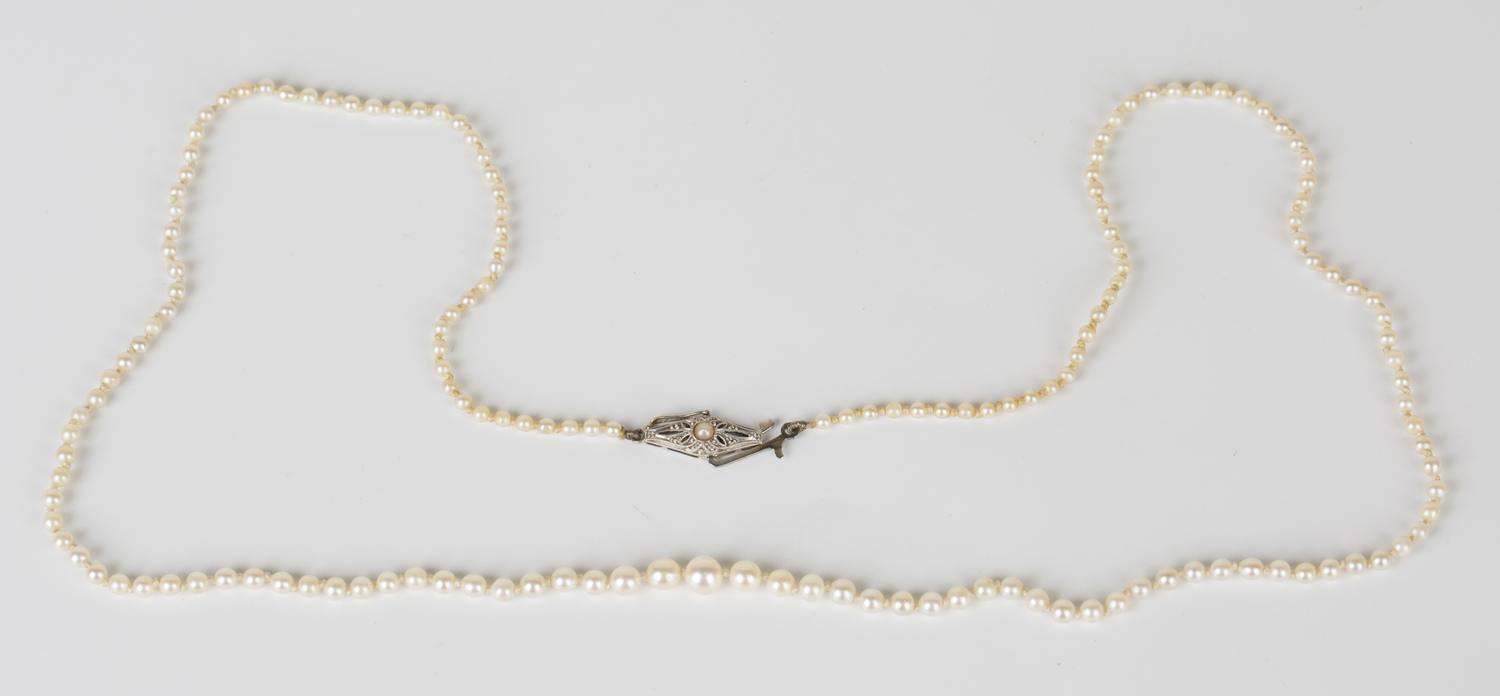 A single row necklace of graduated seed pearls on a white gold and seed pearl set clasp, detailed '