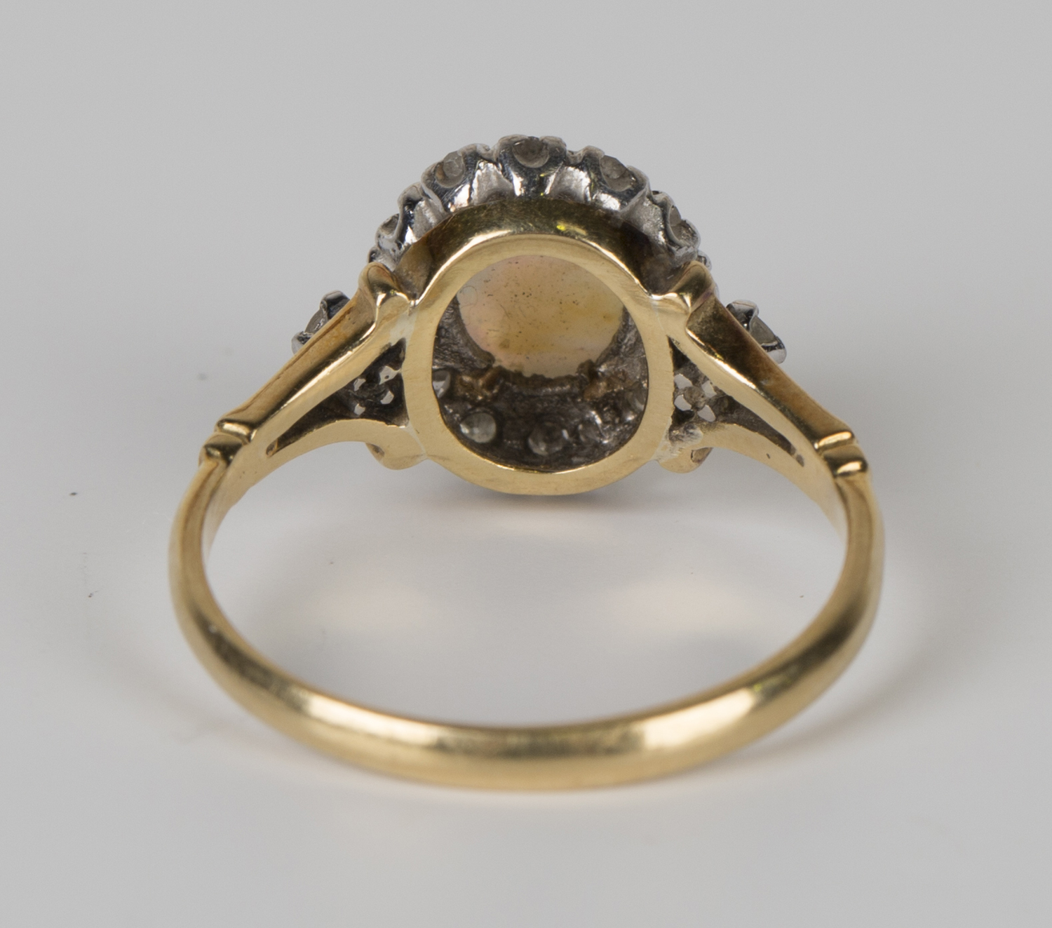 A gold, platinum, opal and diamond oval cluster ring, claw set with an oval opal within a surround - Image 3 of 3