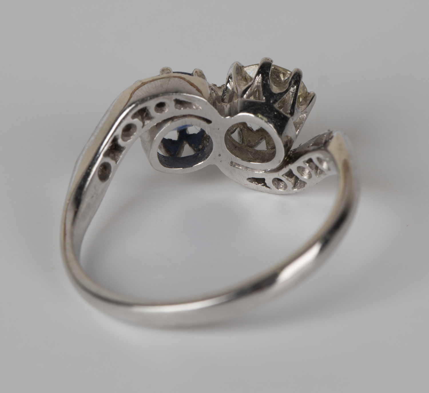 A white gold, diamond and sapphire crossover ring, claw set with the principal circular cut - Image 3 of 3