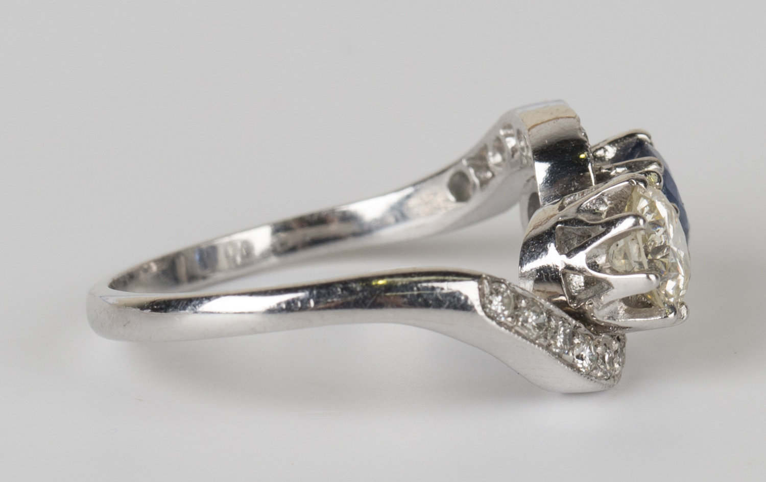 A white gold, diamond and sapphire crossover ring, claw set with the principal circular cut - Image 2 of 3