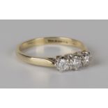 A 9ct gold and diamond three stone ring, claw set with a row of circular cut diamonds, ring size