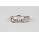 An 18ct white gold and diamond seven stone ring, claw set with a row of circular cut diamonds,