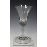 A plain stem wine glass, mid-18th century, the large bell shaped bowl with faintly teared solid