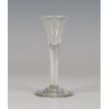 A Jacobite glass, mid-18th century, the small drawn trumpet bowl engraved with a rose and bud on a