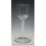 A double series opaque twist stem wine glass, mid-18th century, the ogee bowl raised on a stem