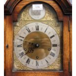 A George V oak longcase clock with eight day movement striking and chiming on gongs, the brass break