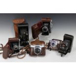 A collection of assorted cameras and accessories, including a Ross Ensign Selfix 820 Special with