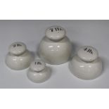 A set of four white glazed ceramic bun weights, late 19th century, comprising 7lb, 4lb, 2lb and 1lb,