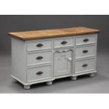 A Victorian style pine and white painted dresser base, fitted with seven drawers and a cupboard,