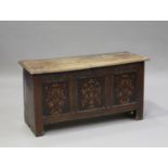 A 17th century oak panelled and boarded coffer, the hinged lid above a carved frieze and a triple