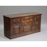 A late Victorian Carolean Revival oak dresser base, fitted with drawers and cupboards, on a plinth