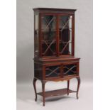 An Edwardian mahogany display cabinet-on-stand, the moulded pediment above a blind fretwork frieze