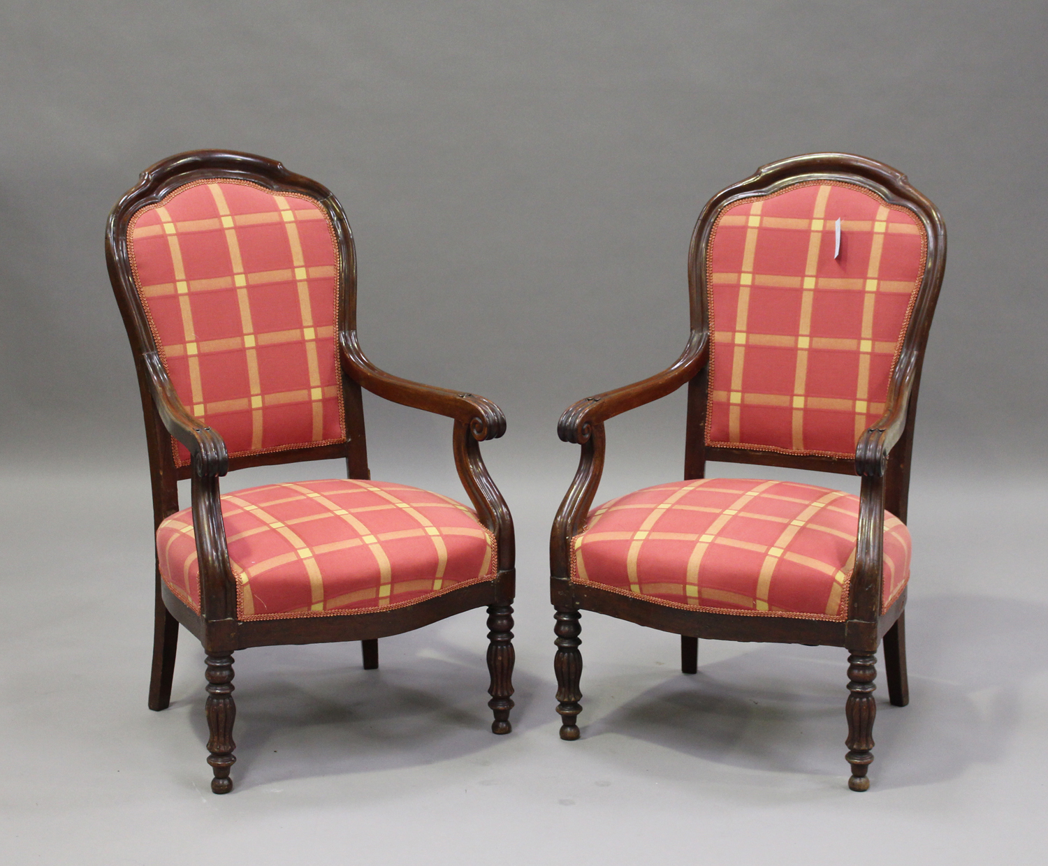 A pair of late 19th century French mahogany showframe armchairs with moulded decoration, the