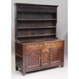 A George III oak dresser, the plate rack with a pierced fretwork frieze, the base fitted with two