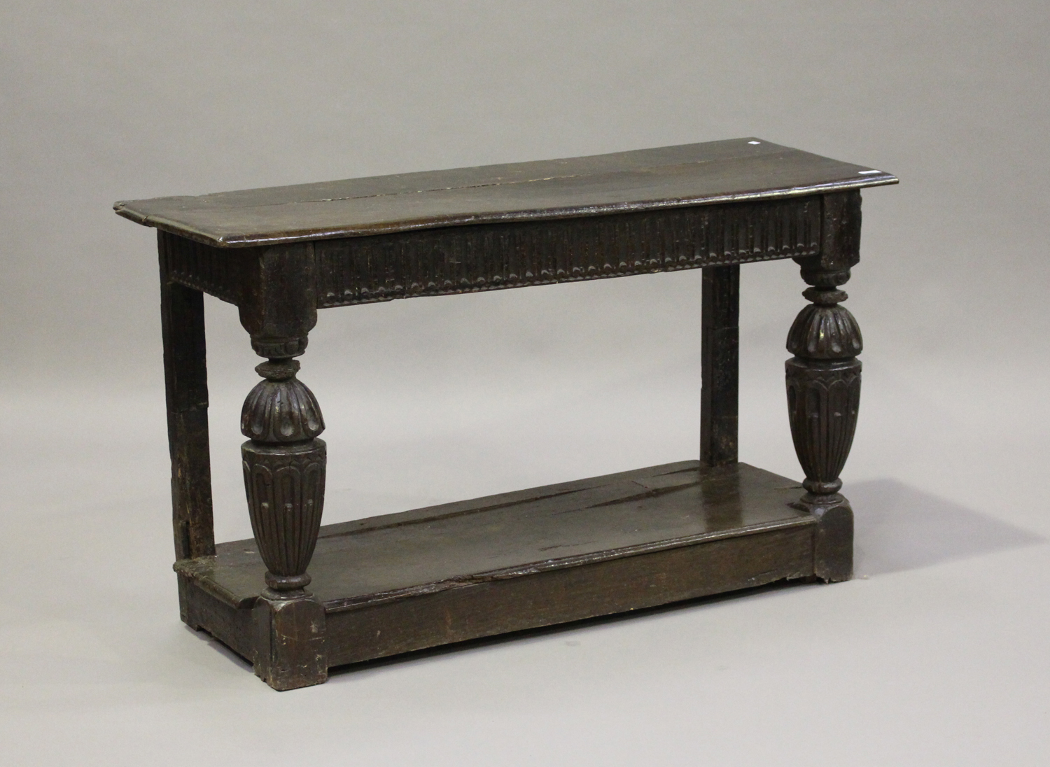A 17th century and later oak console table, the rectangular top above a frieze with carved linenfold