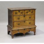A George I burr walnut chest-on-stand, the moulded edge above two short and two long drawers, the