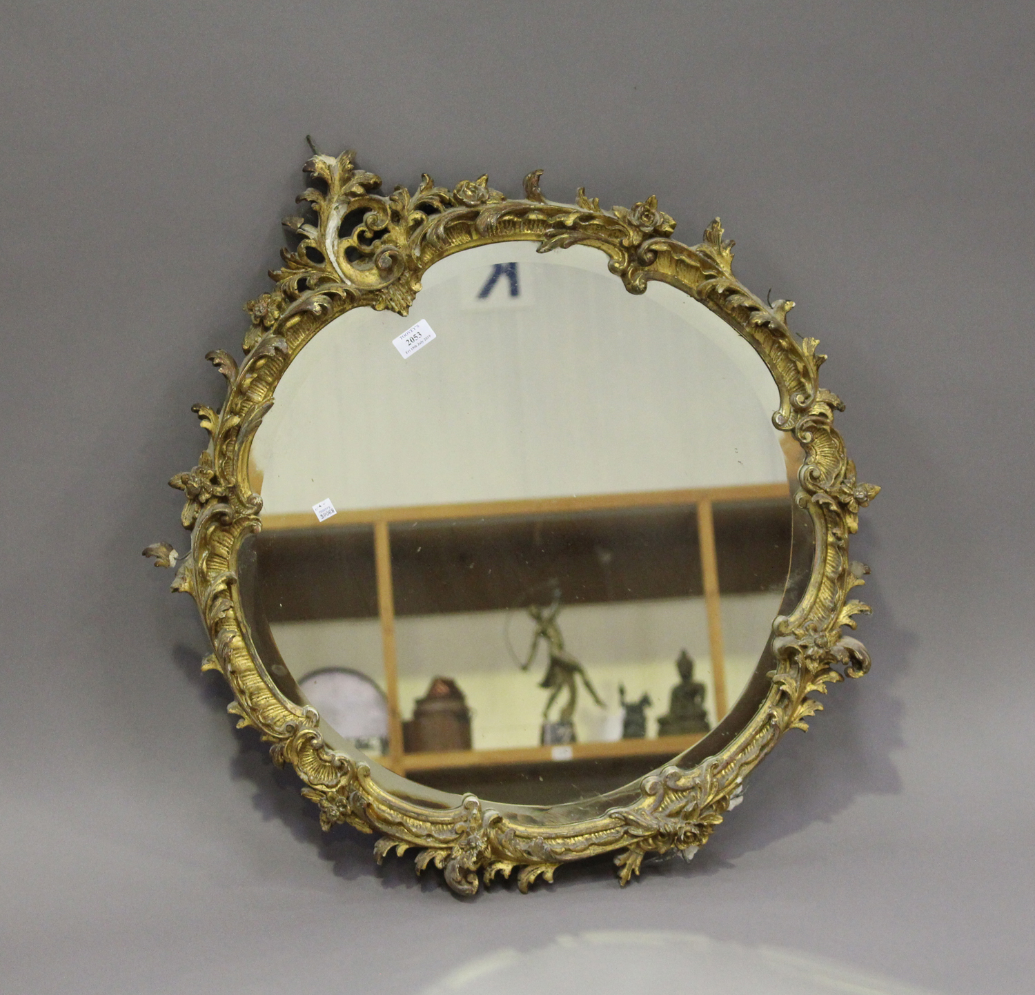 A 19th century giltwood and gesso circular wall mirror, decorated with floral scrolls, 80cm x 71cm.