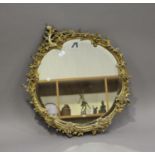 A 19th century giltwood and gesso circular wall mirror, decorated with floral scrolls, 80cm x 71cm.